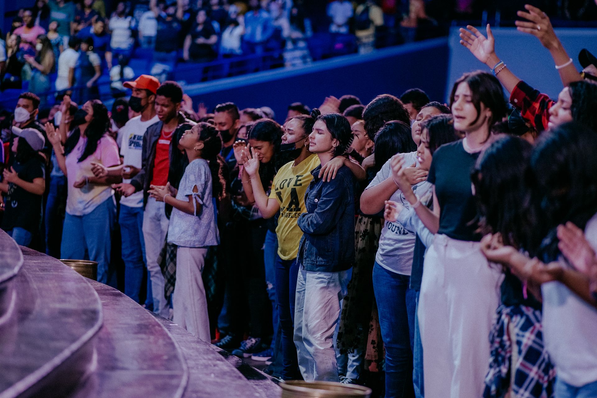 Stock photograph of a crowd praying with hands raised; not a Foundation event